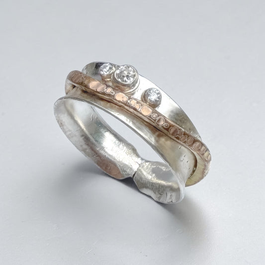 Aprilierre Budding Band Ring showcasing a delicate, minimalist gold ring with subtle floral-inspired design elements.
