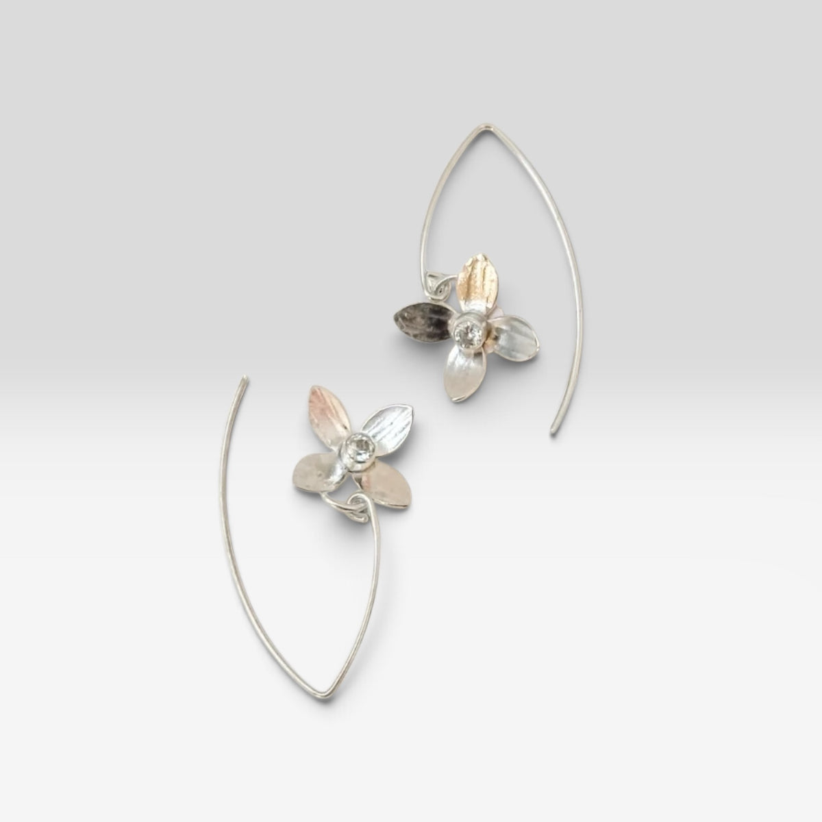 Sterling silver earrings with white topaz gemstones, elegant jewelry by Aprilierre featuring delicate petal-inspired design.