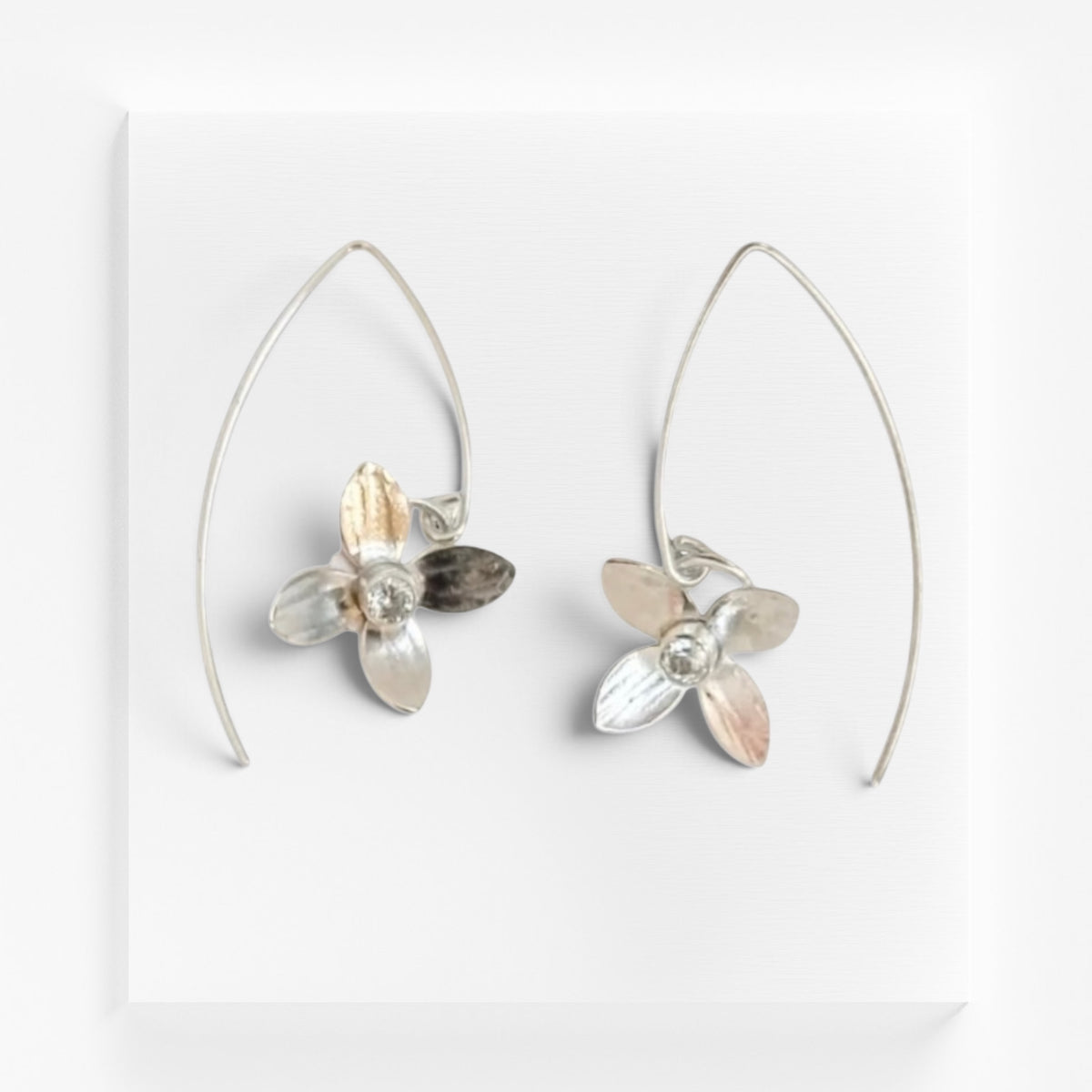 Sterling silver earrings with white topaz gemstones from Aprilierre, showcasing elegant, sparkling jewelry design.